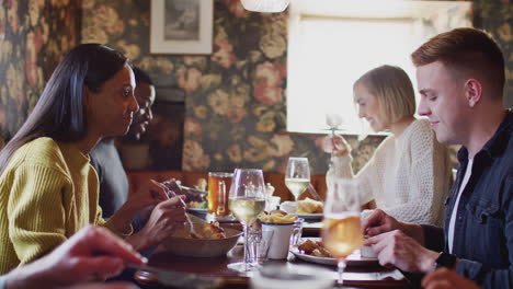 grupo de personas comiendo en un restaurante de un concurrido pub inglés tradicional