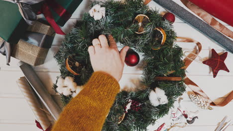 making christmas wreath in timelapse,top view pretty women hands making wreath in lamplight