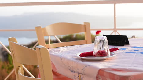 Una-Mesa-En-Un-Restaurante-Griego,-Con-Vista-Al-Mar,-En-La-Isla-De-Santorini,-Grecia