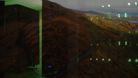 green digital interface animation over winding road through mountainous landscape