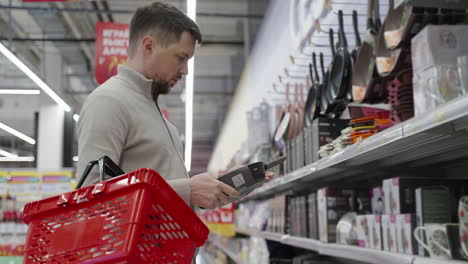 hombre comprando utensilios de cocina en un supermercado