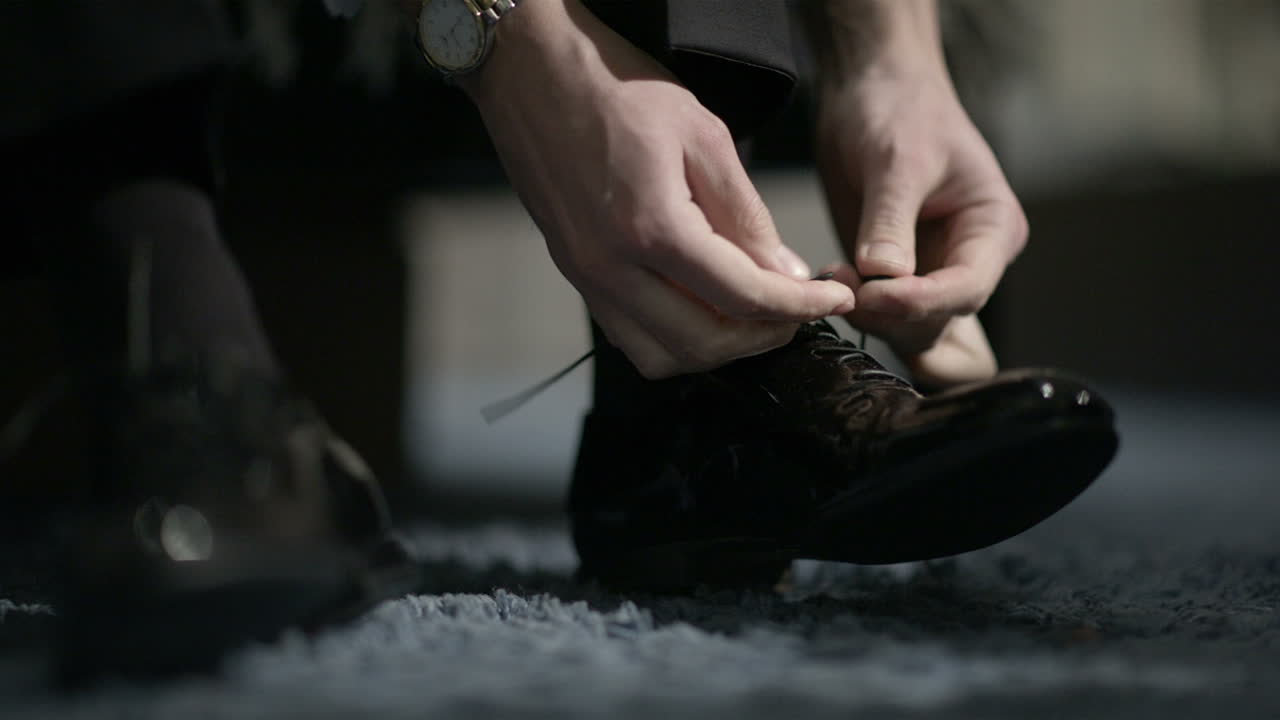 Uomo che si lega le scarpe