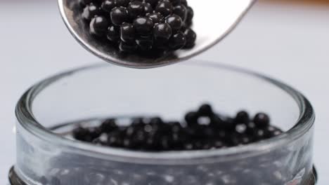 caviar on a spoon over a jar