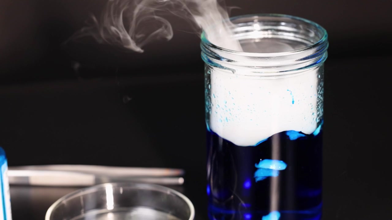 Dry ice reacts with water, creating smoke