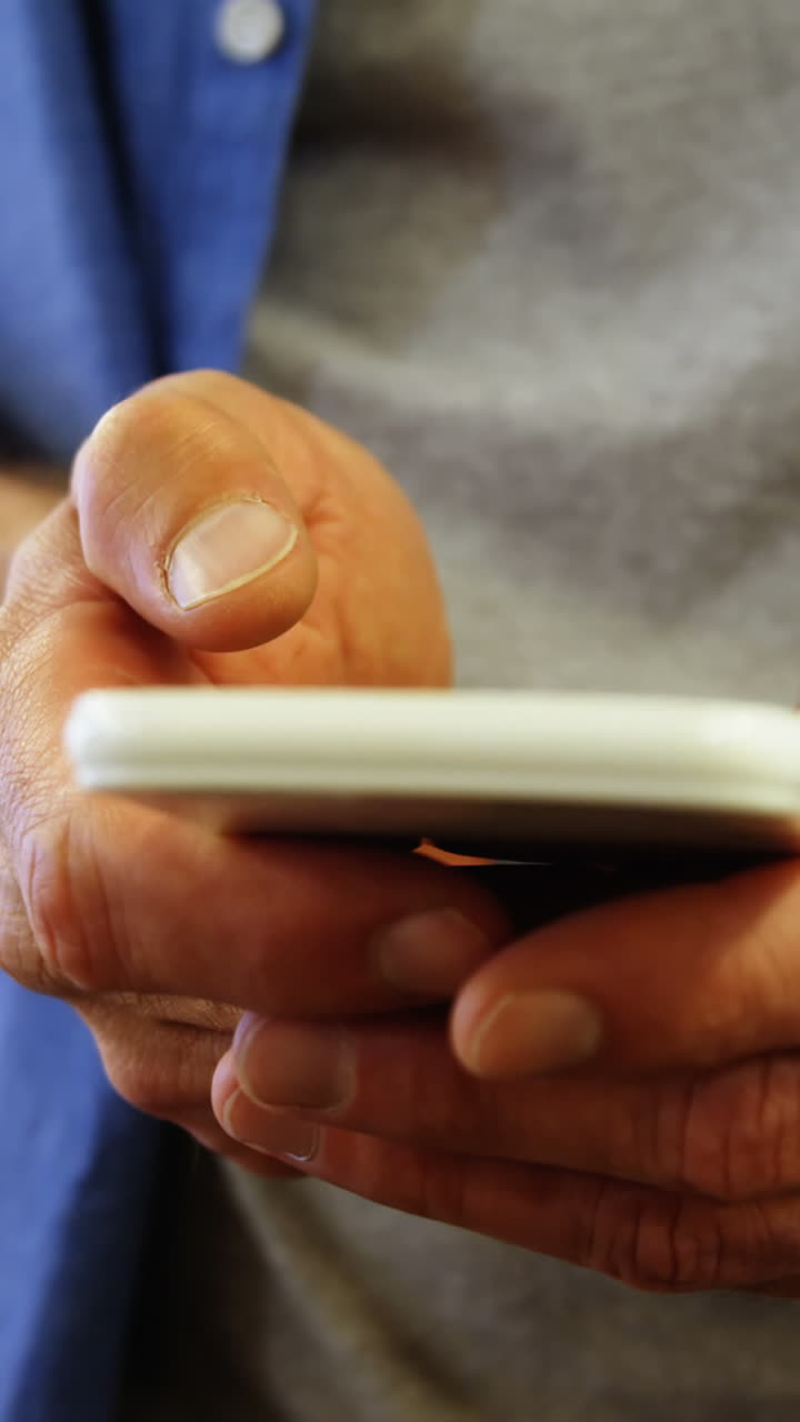 sección media de ejecutivo de negocios masculino mensajes de texto en el teléfono móvil