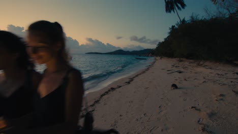 two women enjoying a sunset beach stroll