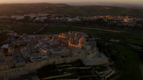 sunset over ancient medieval walled city of mdina in malta - aerial drone shot