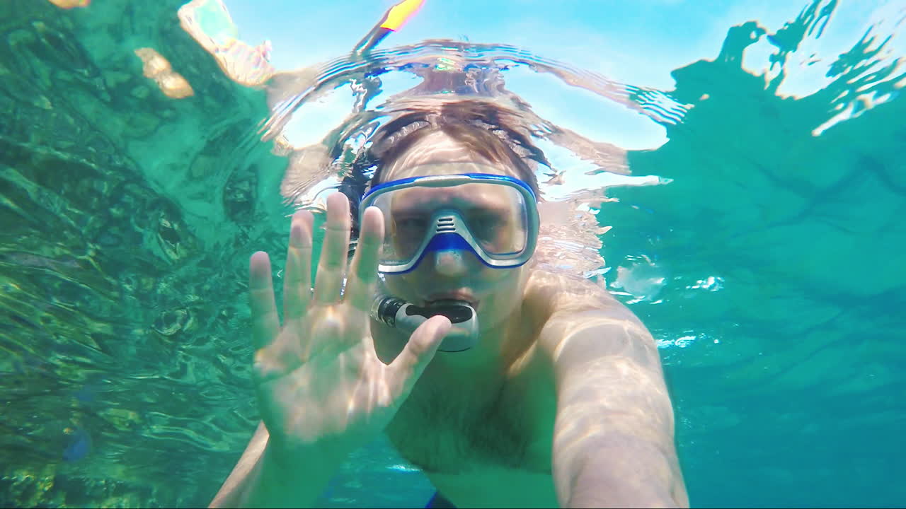 카메라를 향해 손을 흔드는 다이버 - 수중