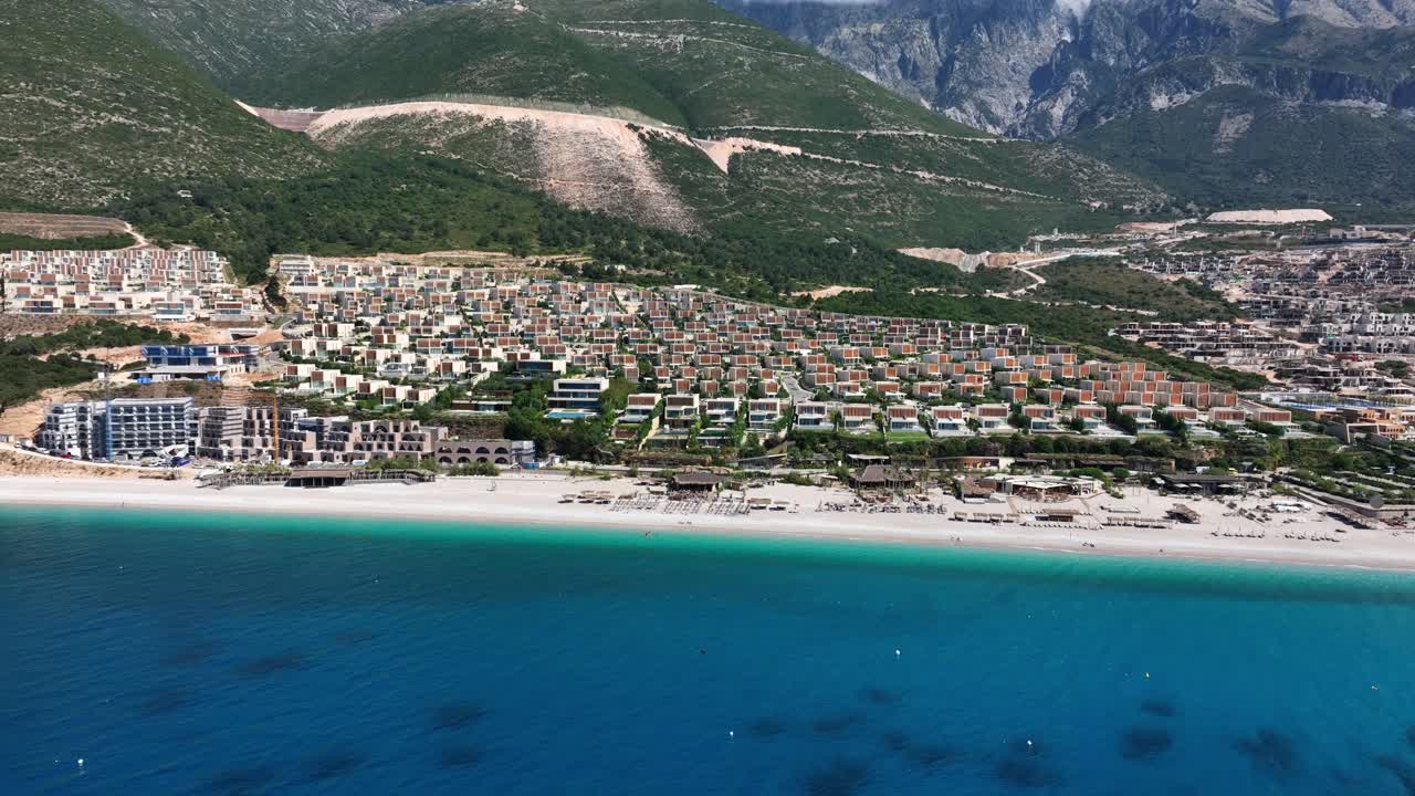 Aerial beach of Green Coast in Palase, Albania with turquoise waters and coastal homes