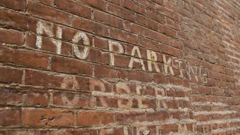 Brick-Wall-with-Painted-No-Parking-Sign---Closeup-from-Left