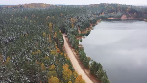 Serene-Passage:-Eine-Malerische-Route,-Die-Das-Verschneite-Seeufer-Und-Die-Satten-Farben-Des-Herbstes-Mit-Stimmungsvollen-Tönen-Umarmt