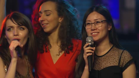 female friends singing in karaoke club