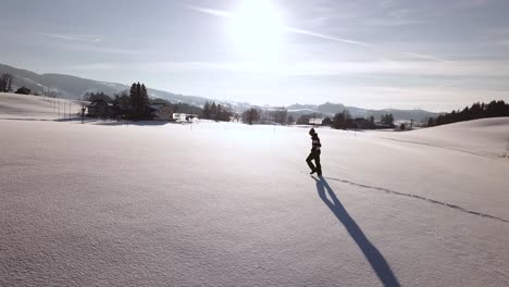 Un-Joven-Con-Ropa-De-Invierno-Camina-Por-Un-Gran-Campo-Nevado-En-Suiza-Durante-El-Invierno