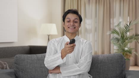 hombre indio riendo mientras ve la televisión