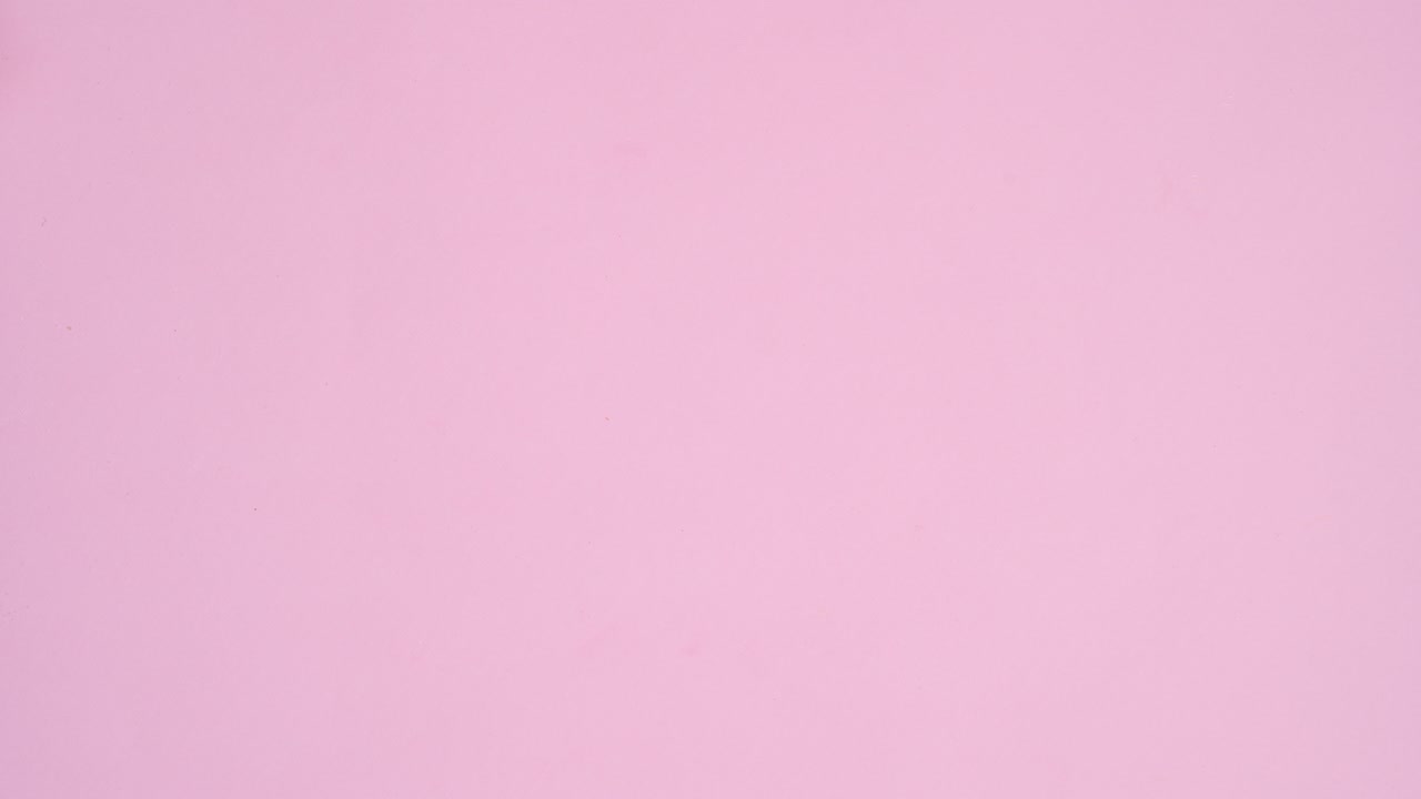 Bowls full with candies chocolates and lollypops appear on left side of pastel pink theme. Stop motion flat lay