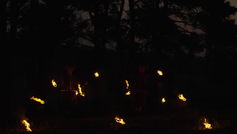 fire jugglers in the woods at night
