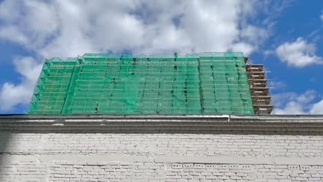 houses renovation program in moscow. construction site covered with safety net.