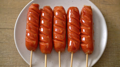 fried-sausage-skewer-on-white-plate