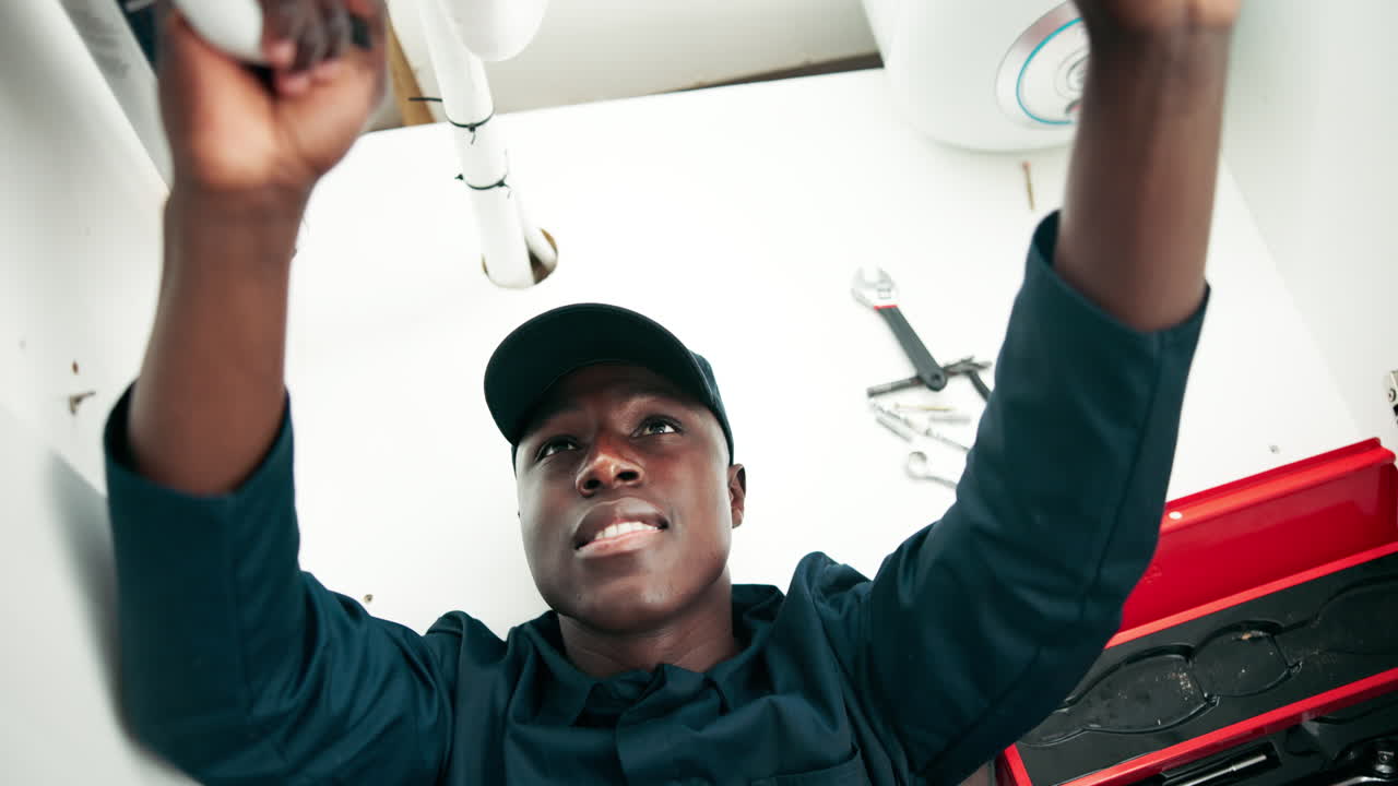 Plumber repairing plumbing under sink