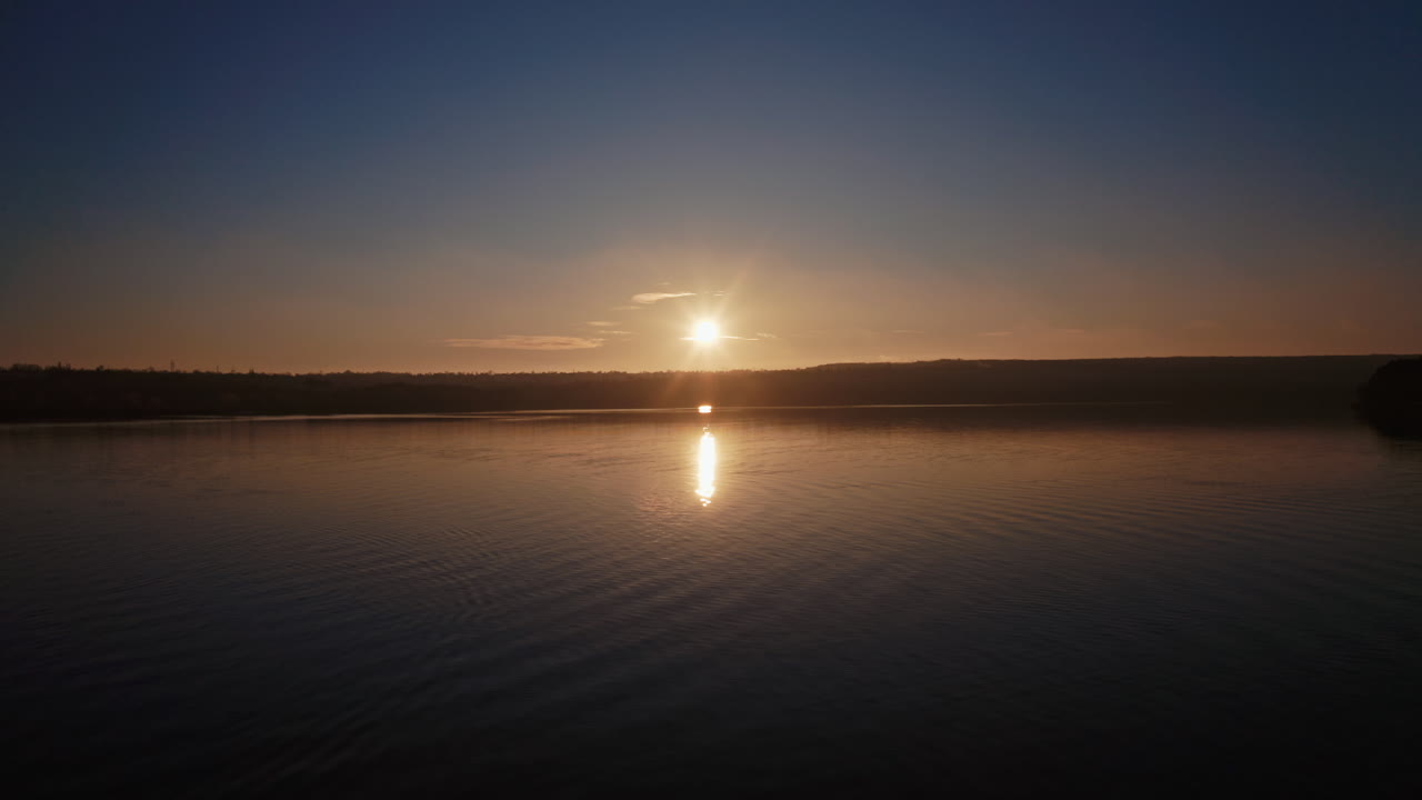 Aerial view of forest and river during sunset. Forest landscape sunset over water cinematic drone footage