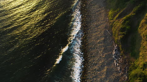 aerial view of pacific ocean waves gently rolling onto rocky shore, oregon coast