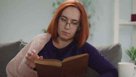 ama de casa concentrada en gafas lee un libro volviendo páginas
