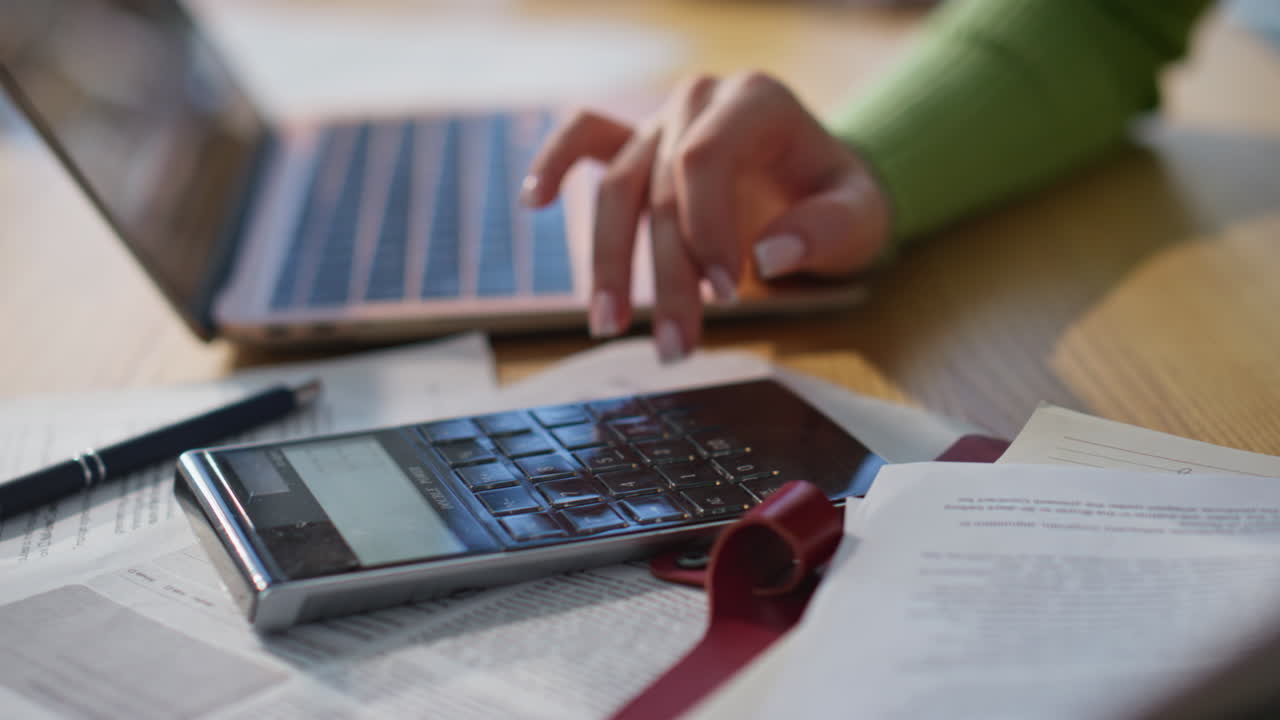 Woman hand calculating budget at workplace closeup. Lady pressing calculator