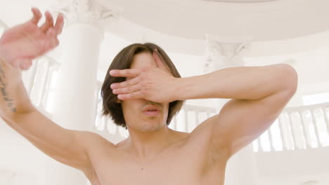 스튜디오에서 눈을 가린 현대 남성 일본 댄서 훈련 댄스 동작의 클로즈업 보기