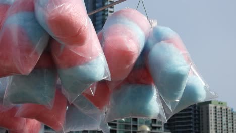 pink and blue cotton candy hanging. handheld, low angle