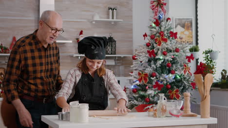 grandchild preparing gingerbread homemade dough using rolling pin making delicious dessert