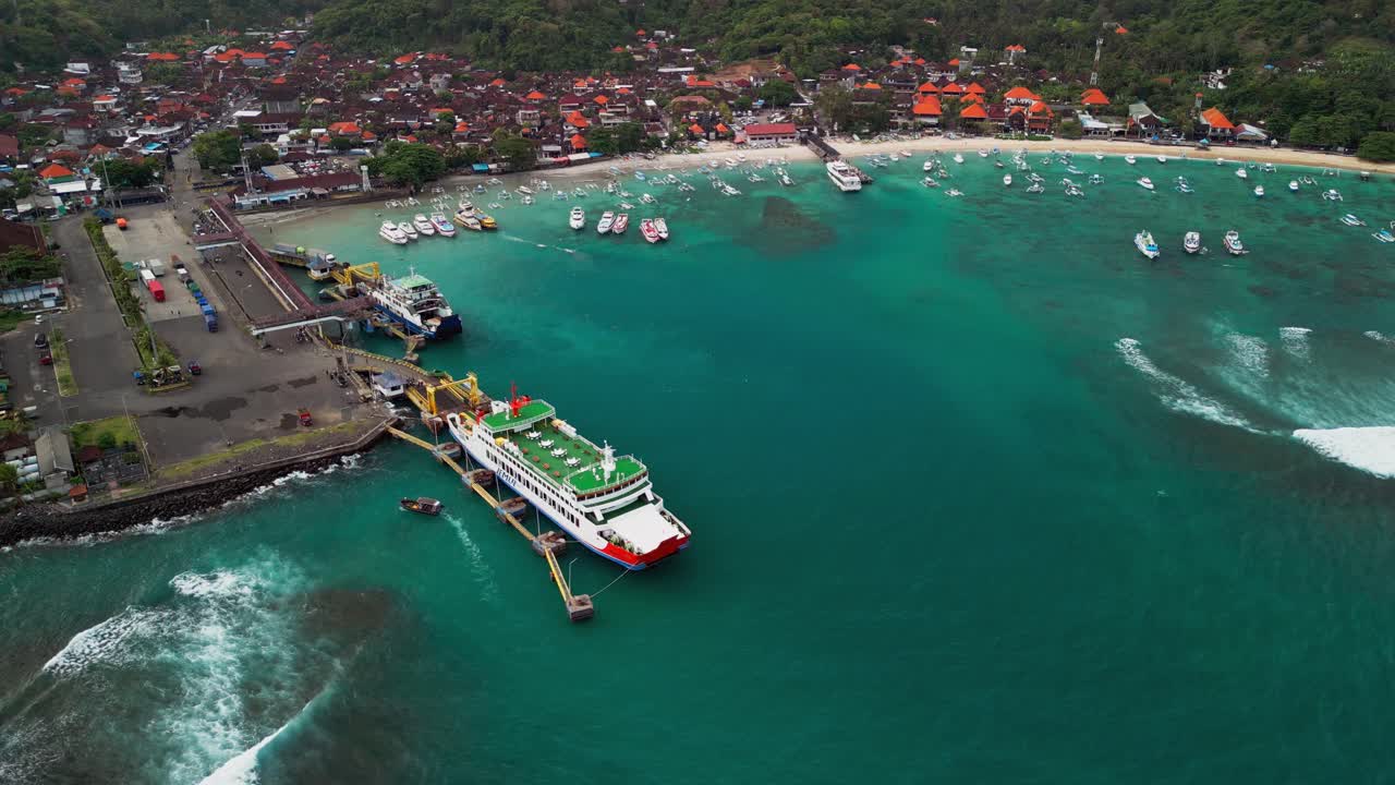 Stunning drone footage revealing Padang bai Harbor’s curved shoreline, crystal sea hues, and ferries ready for island crossings, highlighting Bali’s coastal charm and tropical marine life