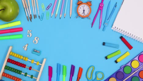 School stationery and tools appear and make frame for text on blue theme. Stop motion