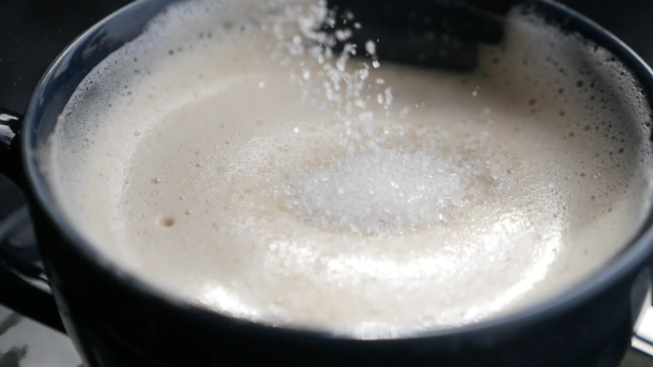 Primo piano di una tazza di caffè con zucchero