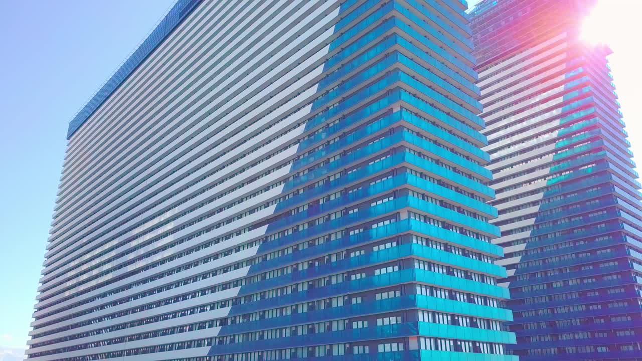 도시 마천루의 유리 창문에서 태양, 구름, 하늘의 반사 사진입니다.