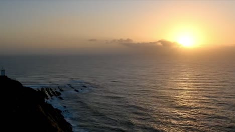 el lapso de tiempo del amanecer sobre el océano con el faro en mosselbay en sudáfrica