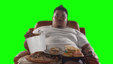 greedy man watching tv while eating junk foods