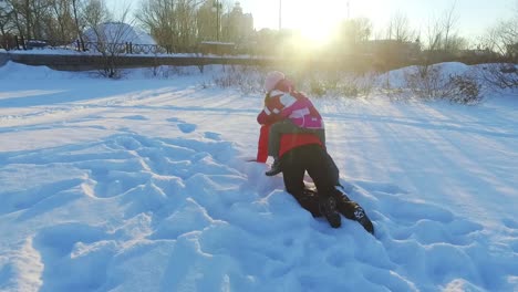 Fröhlicher-Winterspaß-Im-Schnee.-Mutter-Spielt-Mit-Tochter-Im-Sonnigen-Winterpark