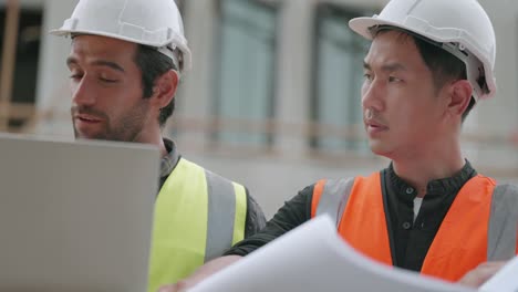 construction engineer meeting with team contractor talking and explain housing construction model in laptop and blueprint. male and female worker working at construction site in real estate business.