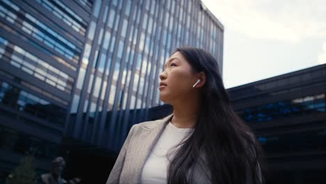 Mujer-China-De-Negocios-Parada-En-La-Calle-De-La-Ciudad-Y-Mirando-A-Su-Alrededor