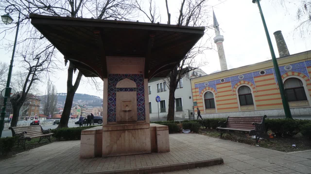 사라예보, 보스니아 헤르체고비나 - 2019년 10월 19일: 사라예브의 공원에서 물 분수, 배경에는 페리어 모스크 미나이 보인다.