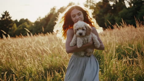 woman and puppy enjoying golden hour in a field