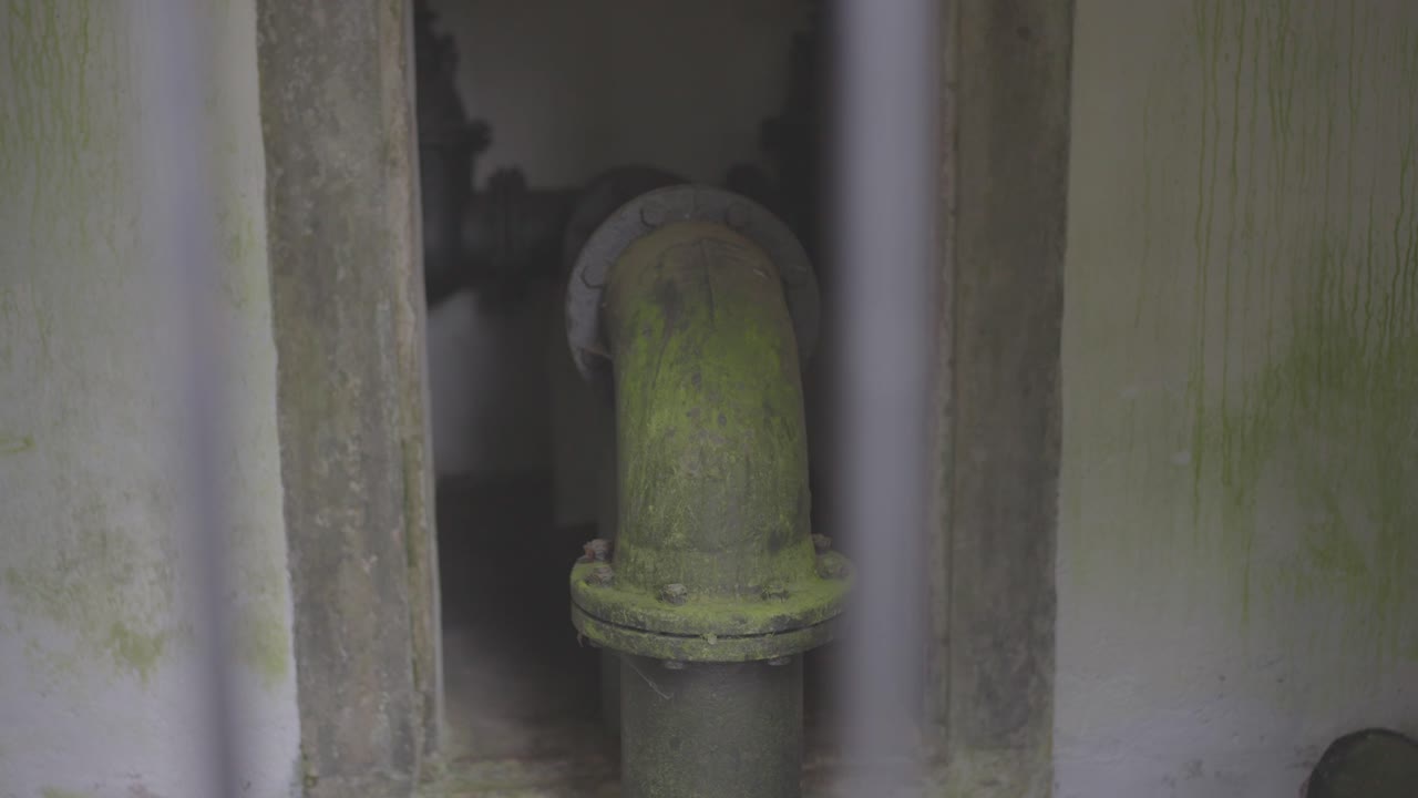 Old water pipes overgrown with moss and corrosion