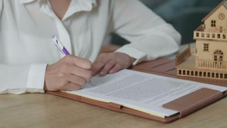 mujer firmando documentos de bienes raíces