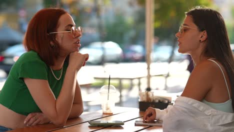 dos mujeres teniendo una conversación en un café