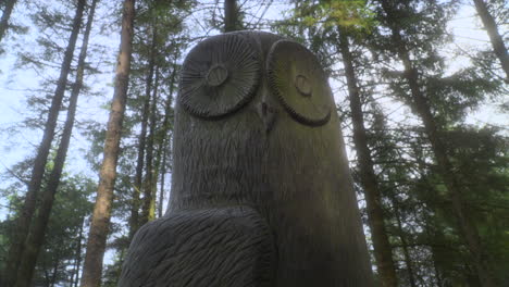 Eulenskulptur-Im-Englischen-Wald-Mit-Sonnenlicht,-Das-Auf-Die-Skulptur-Fällt-Und-Sehr-Langsamer-Schwenk