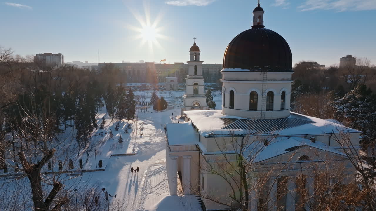 Aerial drone view of the Bell tower of the Metropolitan Cathedral of Christ's Nativity. City center covered in snow at sunset in Chisinau, Moldova