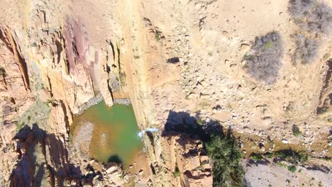 vertical drone shot of the waterfall between desert mountains in bousaada algeria