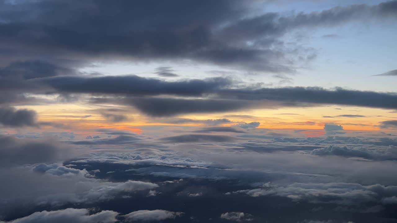 impresionante cielo al atardecer como lo ven los pilotos de un avión mientras vuelan a 12000 m de altura hacia el oeste a pesar de algunas nubes coloridas y esponjosas