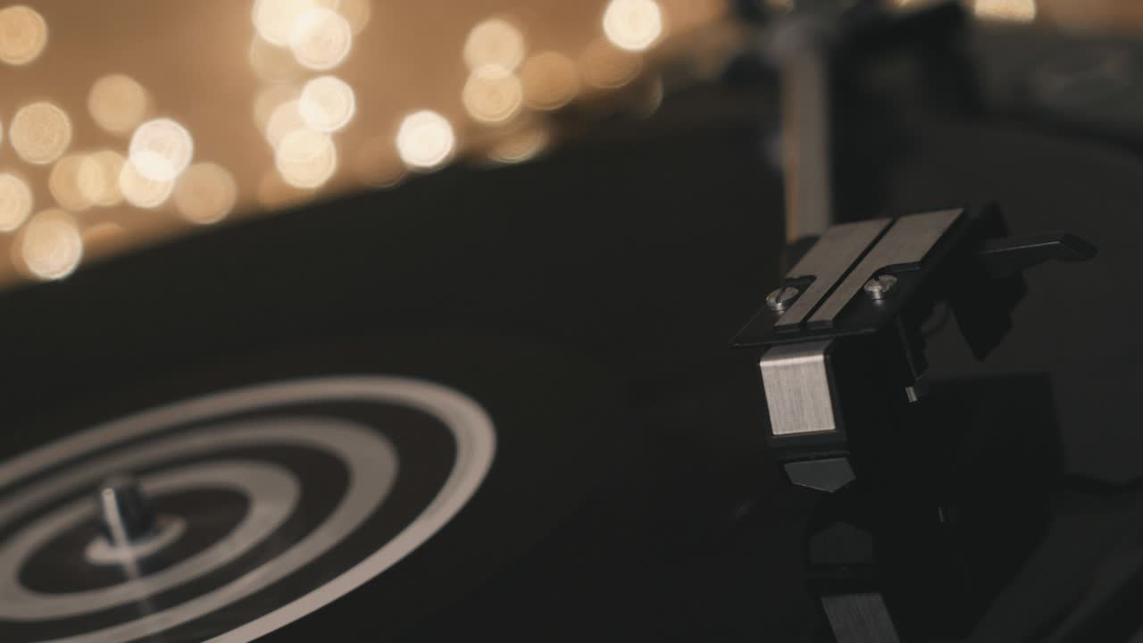 턴테이블 비닐 레코드 플레이어: 초점에서 디포커스: 가운 배경에서 그라모폰과 토크 플레이트 클로즈업; 밝은 보케를 배경으로 바늘 클로즈업을 가진 스타일러