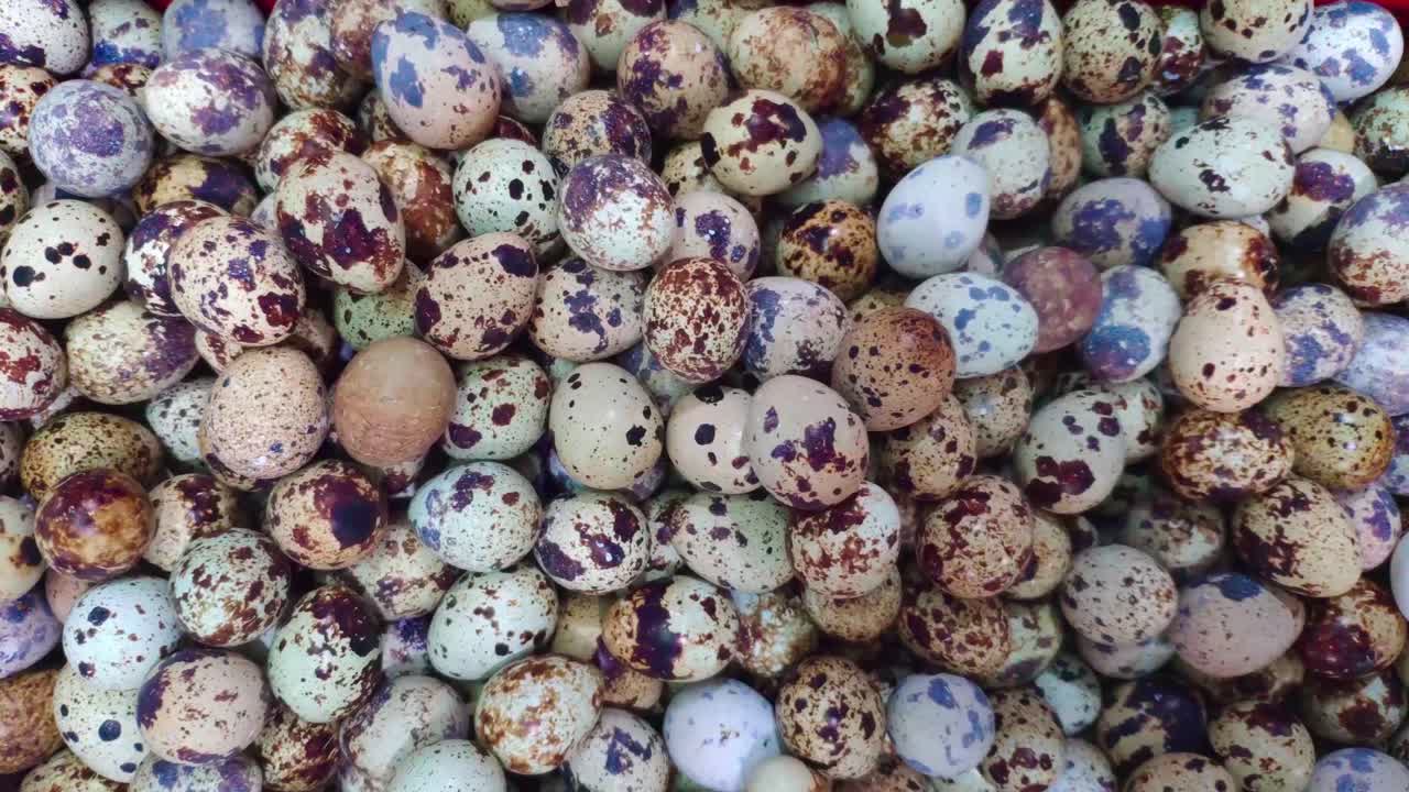 Top shot of a pile of quail eggs in a basket for sale